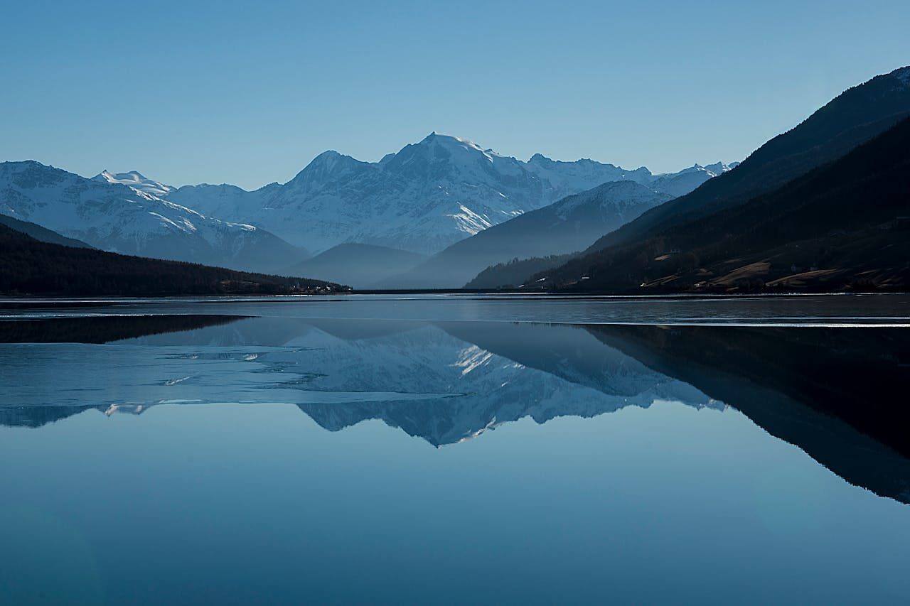 Calm lake with mountains reflected in perfectly still water