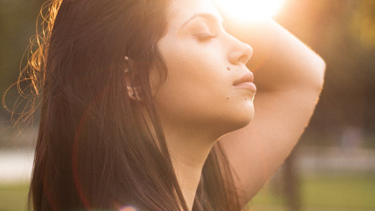 Person resting with closed eyes in warm sunlight