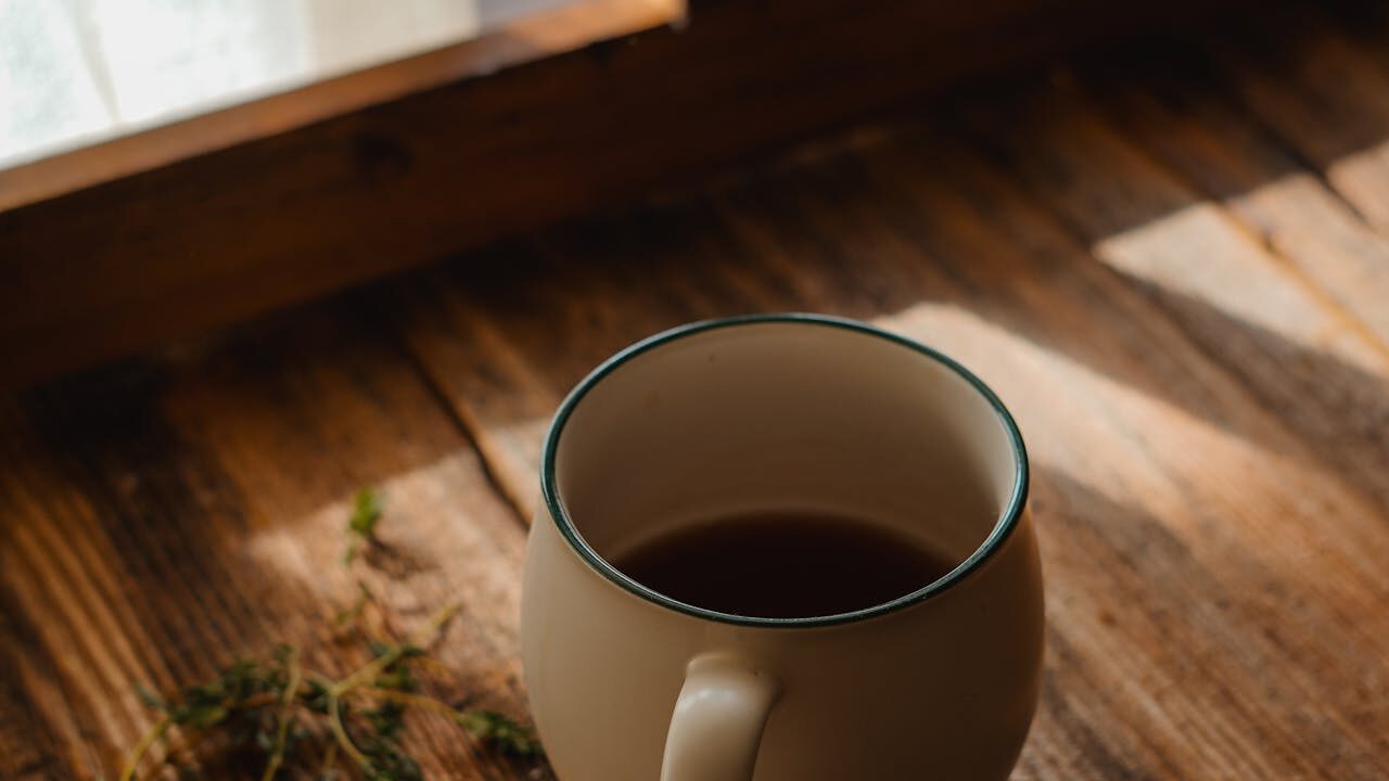 A warm cup of tea surrounded by soft blankets in morning light